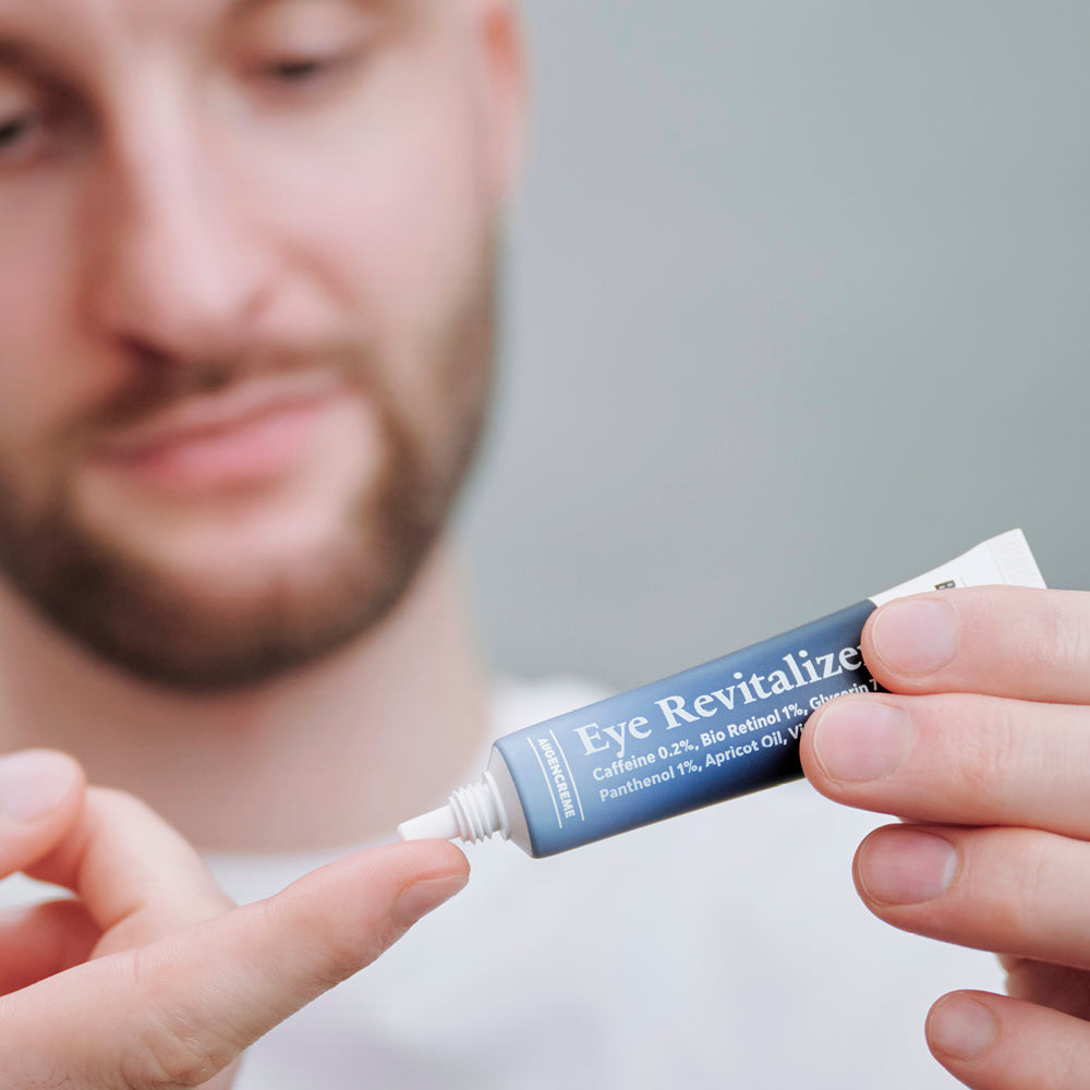 Mann trägt Eye Revitalizer Augencreme von Brooklyn Soap Company auf – feuchtigkeitsspendende Pflege gegen Schwellungen und Falten.
